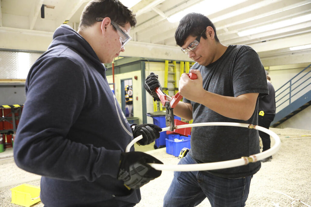 Students fitting pipes together in a lab