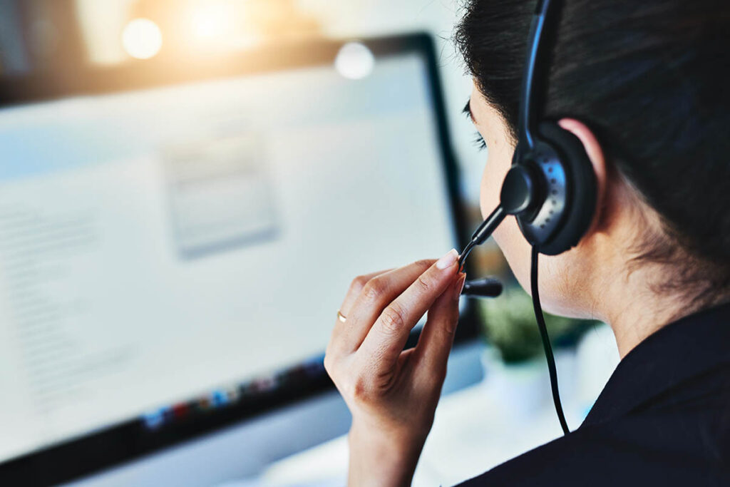 Woman wearing a headset and looking at a computer screen