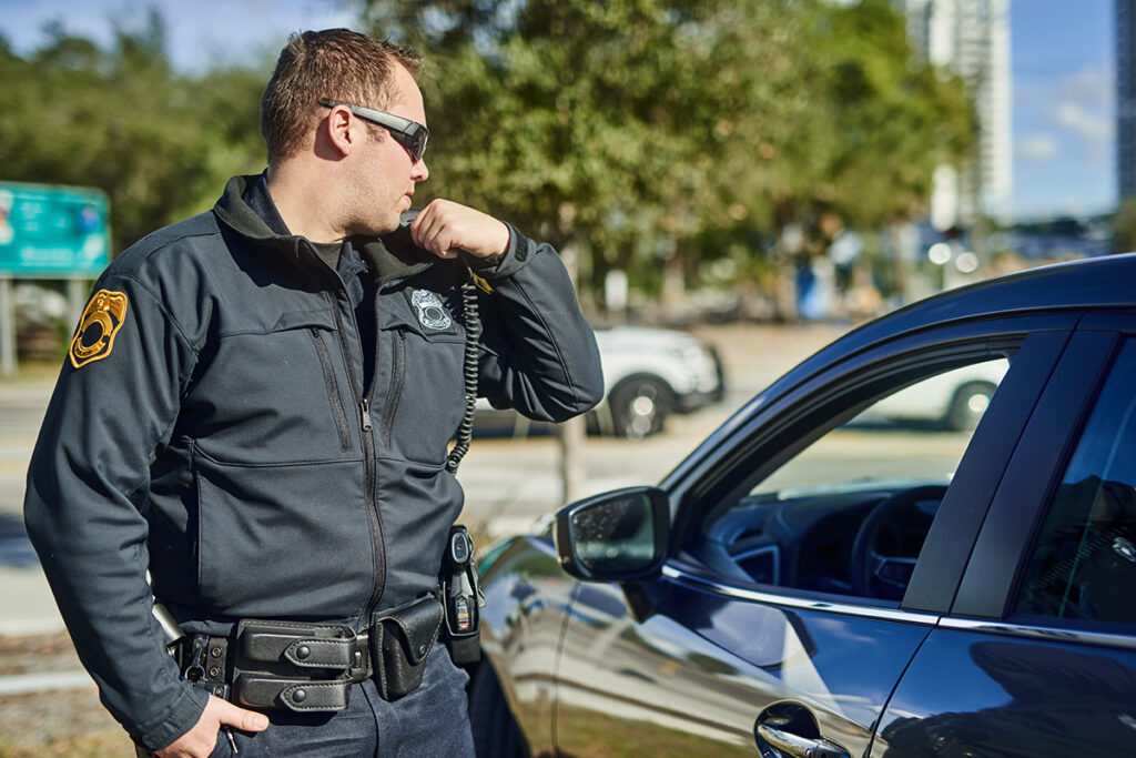 Security officer using a radio in a parking lot