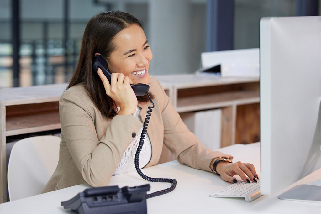 Smiling administrative assistant talking on the telephone in an office