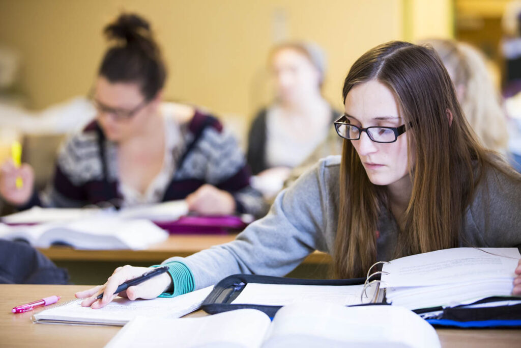 Student taking notes in a classroom