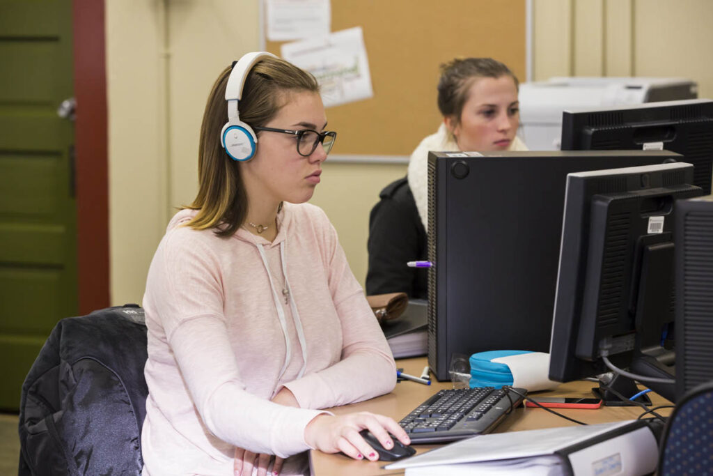 Woman wearing headphones using a computer