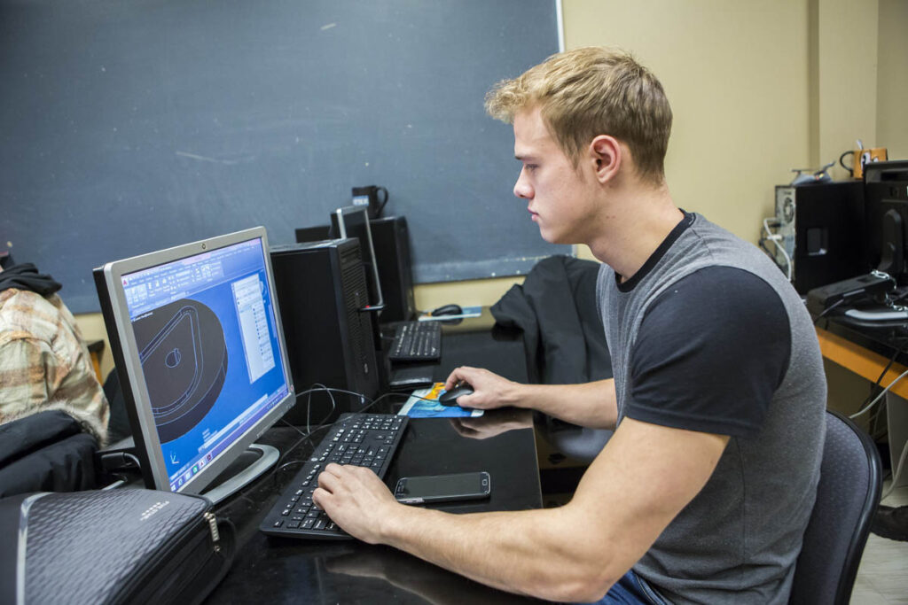 Student looking at CAD drawings on a computer screen in a computer lab