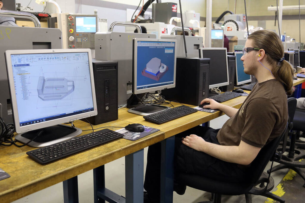 Student looking at CAD drawings on a computer screen in a computer lab