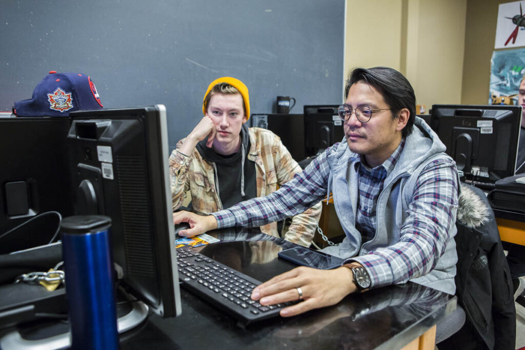Two students sitting in a computer lab working on a computer