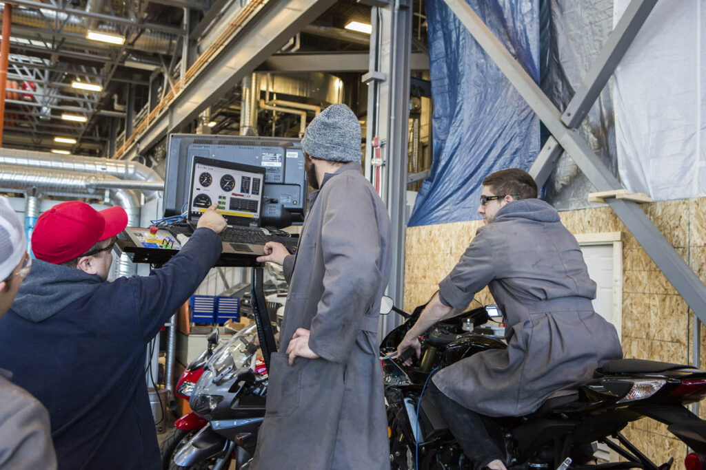 Students using a computer to inspect a vehicle