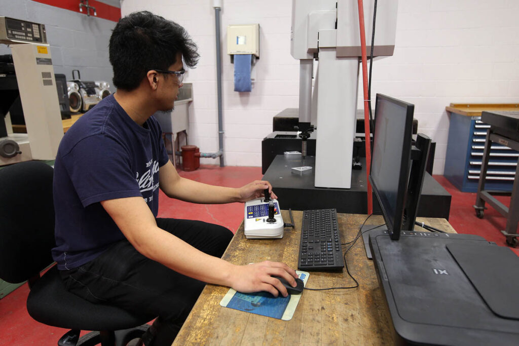 Student working with milling equipment in a lab