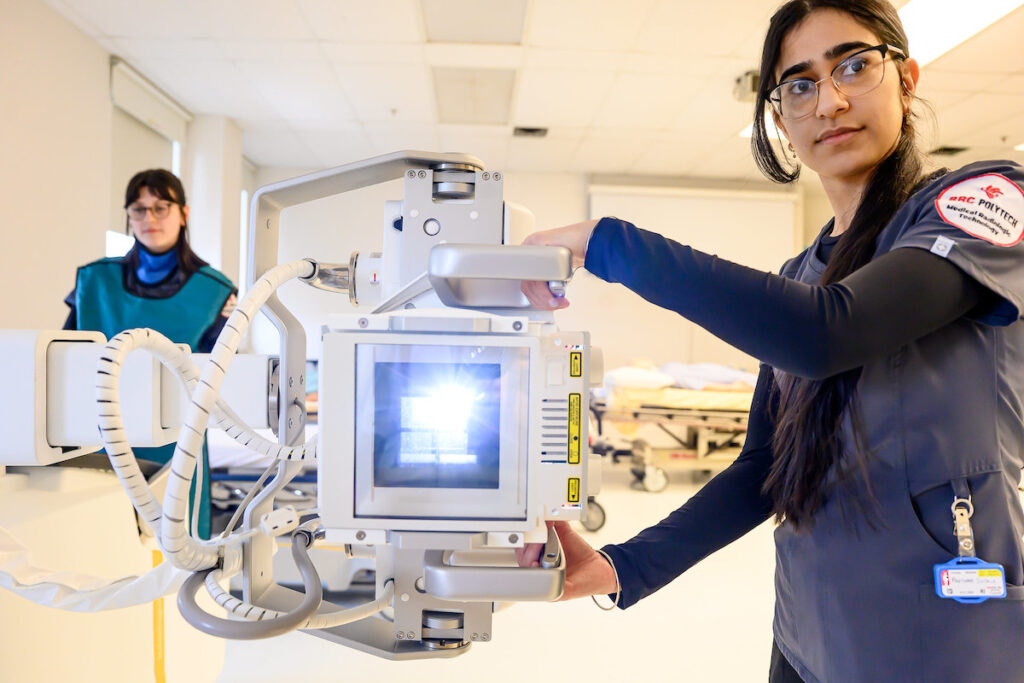 Radiologic technologist student operating imaging equipment in a lab