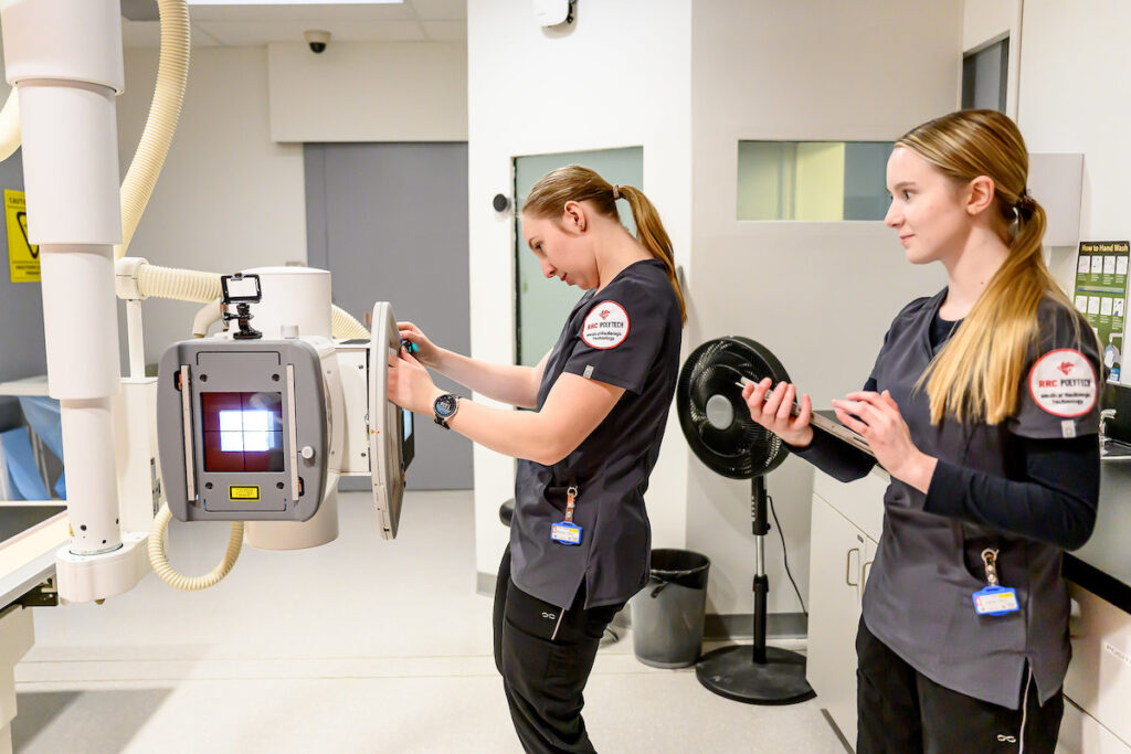 Radiologic technologist students operating imaging equipment in a lab