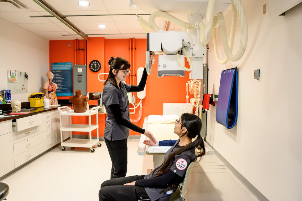 Two radiologic technology students talking in a lab
