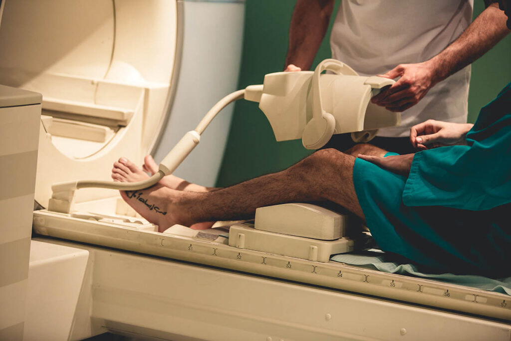 MRI technician getting patient's leg ready to be scanned