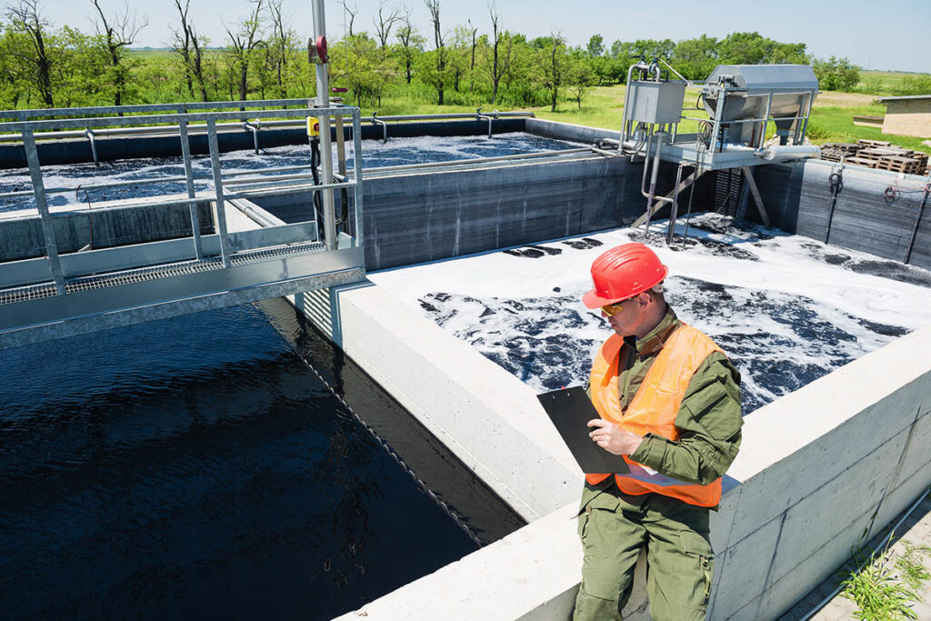 Engineer with a clipboard taking notes at a water treatment facility