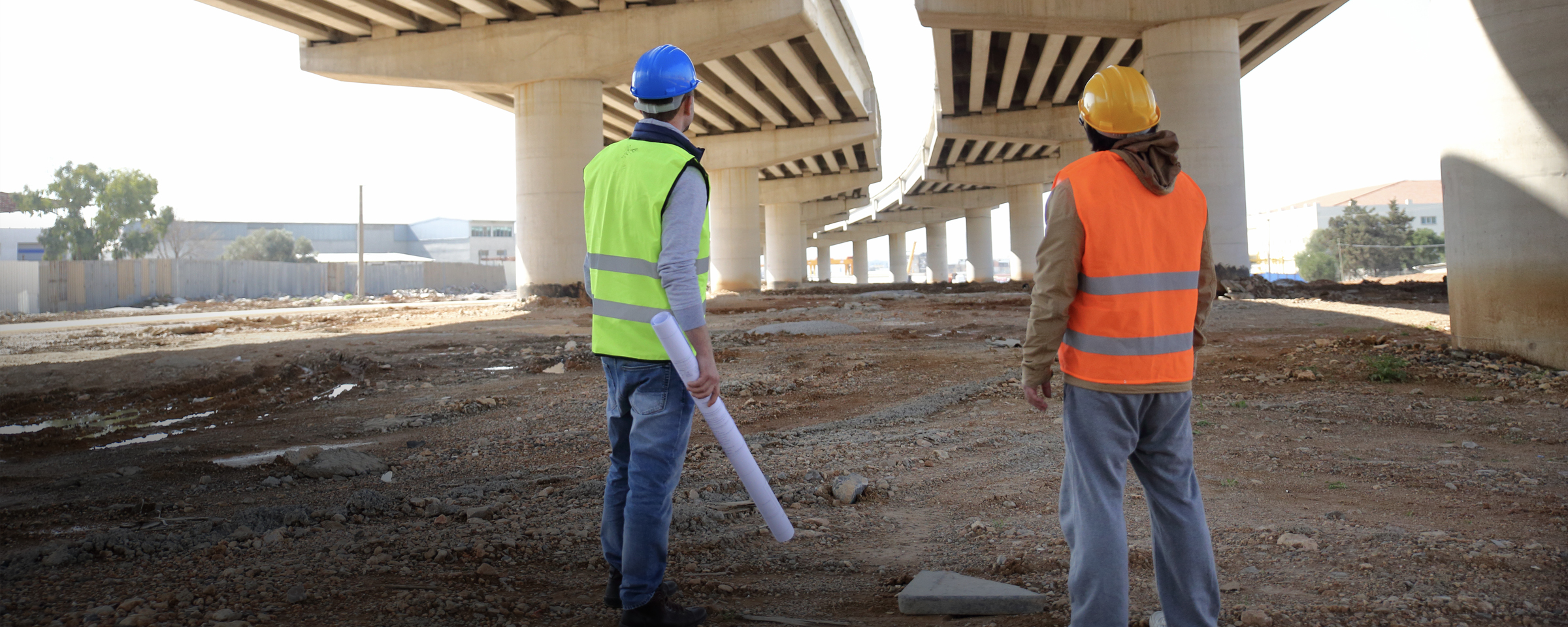 Two engineers looking at the underside of an overpass under construction