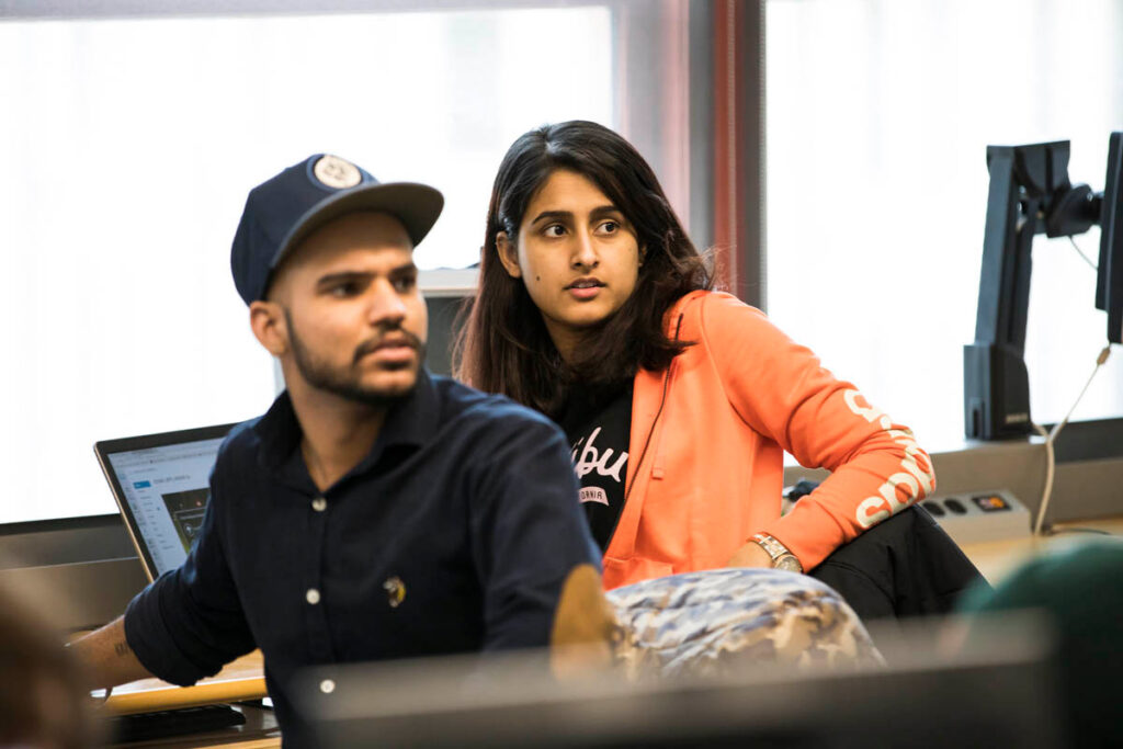 Students in a classroom looking over their shoulders at something