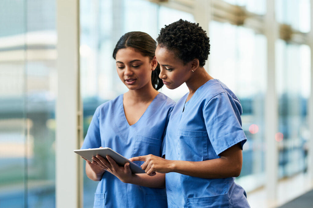 Two nurses reviewing chart on tablet