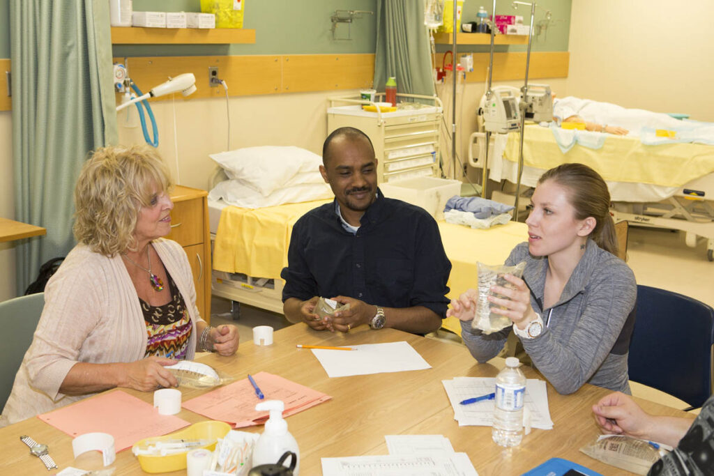 Instructor talking to nursing students in hospital lab