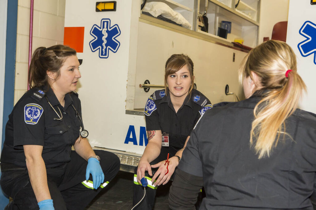 Paramedicine students talking to each other near ambulance learning lab
