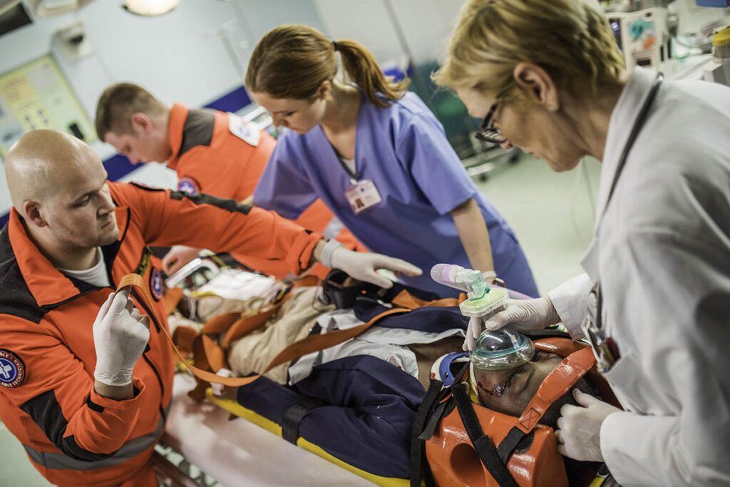 Paramedics wheeling a patient into a hospital