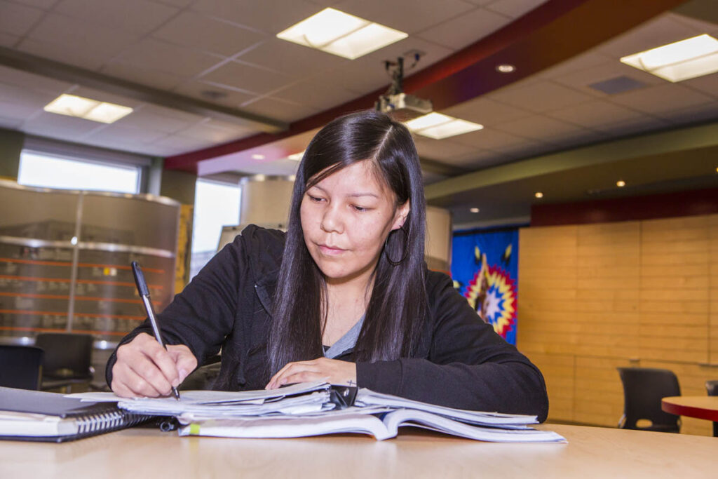 Woman writing in a notebook in a classroom