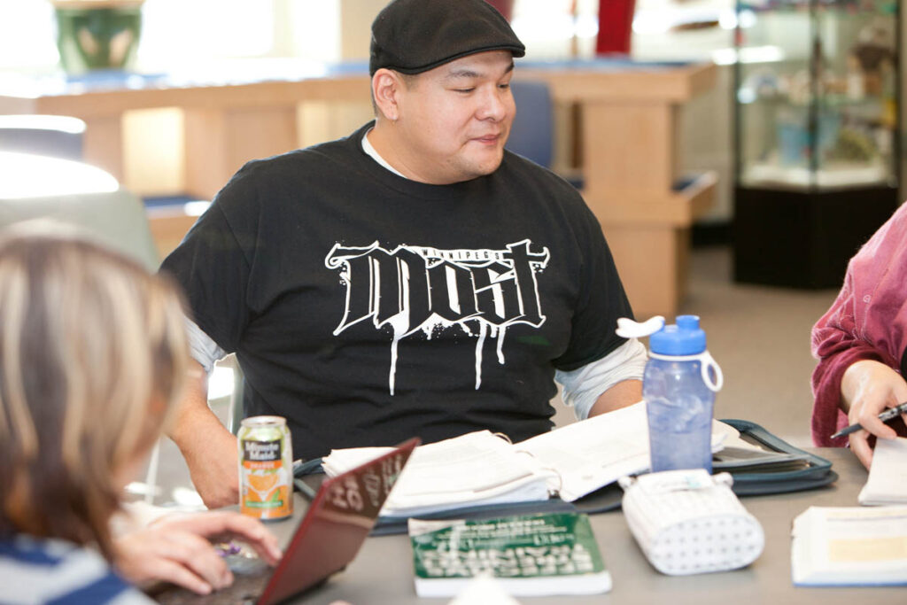 Guy sitting in a classroom reading notes