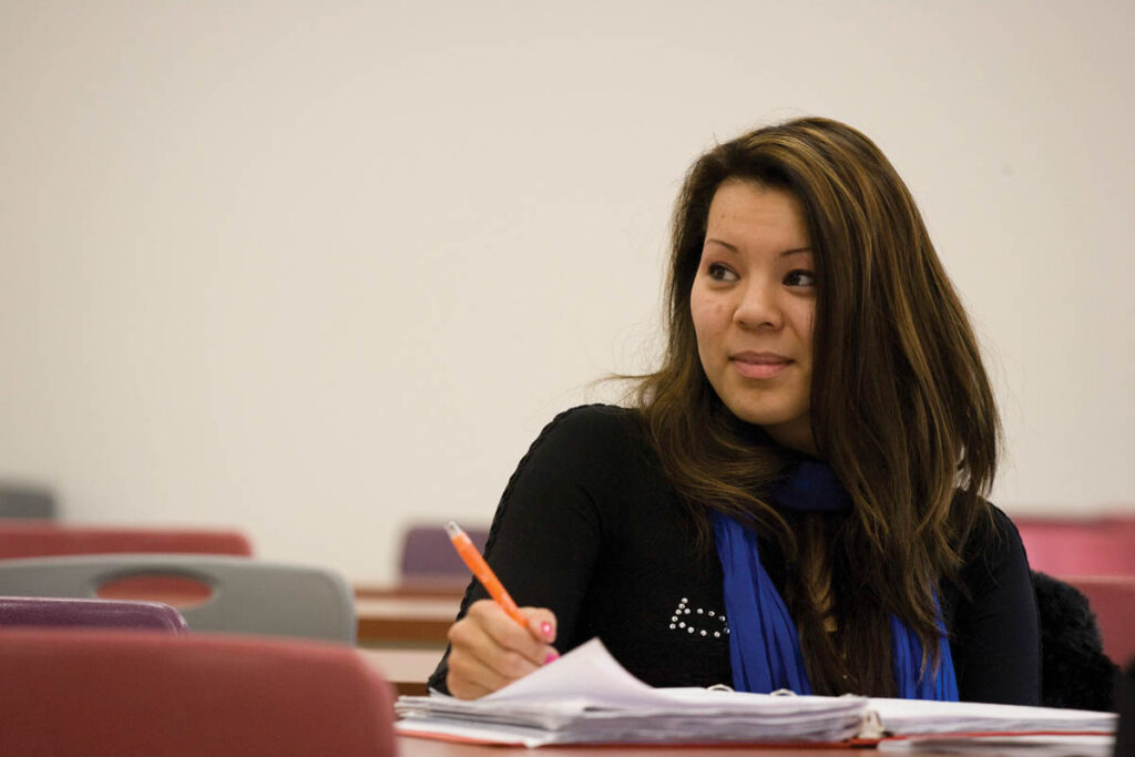 Student sitting in a classroom taking notes