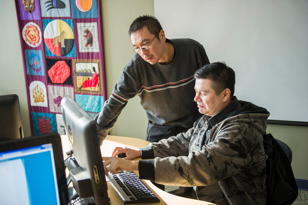 Instructor talking to student in a computer lab