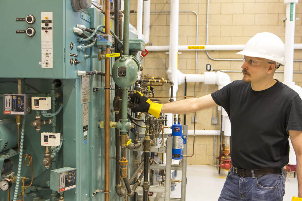 Power engineer looking at boilers in learning lab