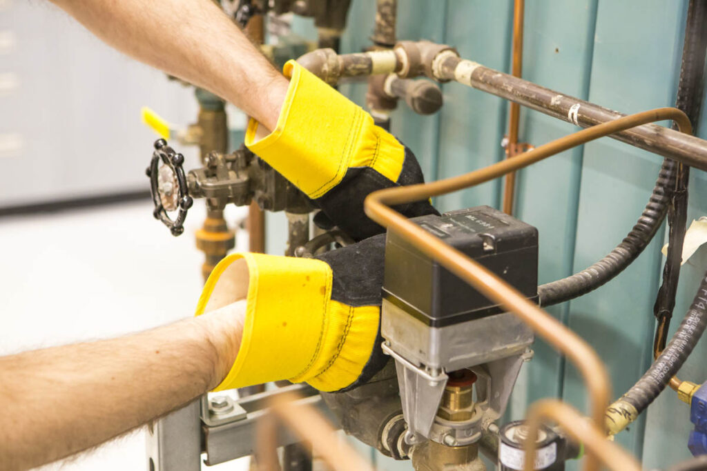 Person adjusting fitting of copper pipes