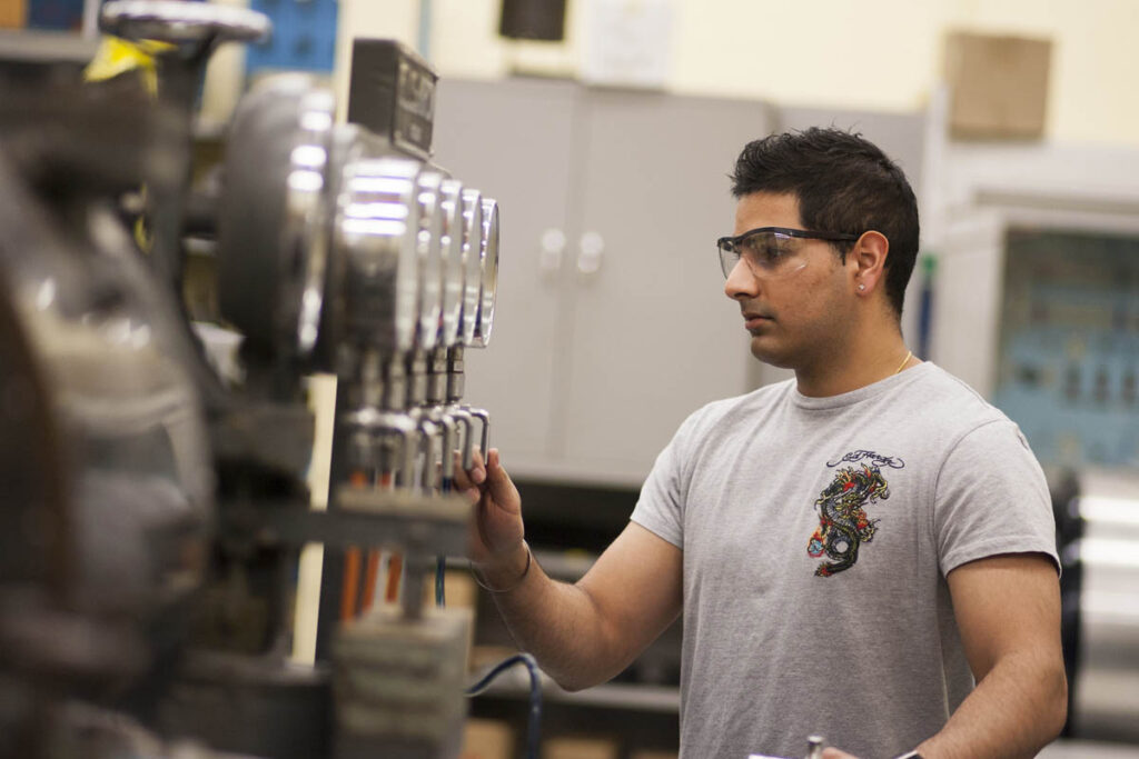 Power engineer looking at gauges on boiler