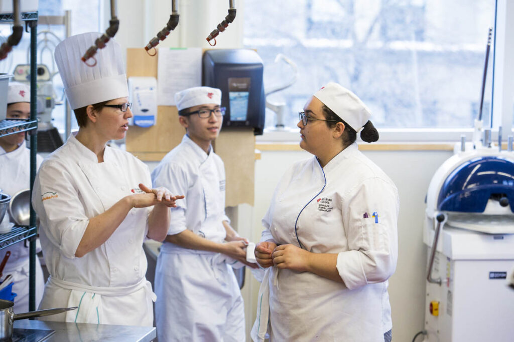 Baking students talking to each other in a kitchen