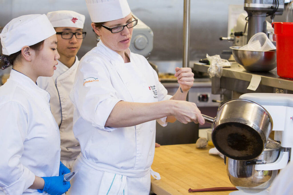 Baking instructor showing students how to bake something