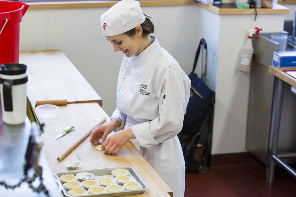 Baking student in a kitchen working with dough