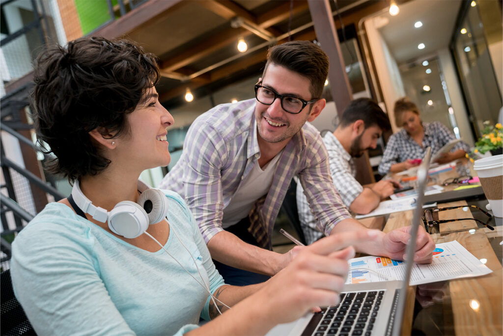 Two colleagues talking to each other in a modern looking office