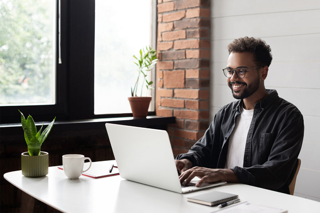 Smiling man working on a laptop 