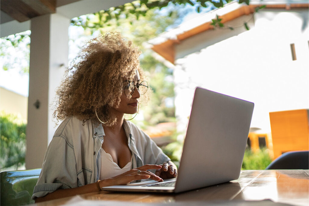 Woman working on a laptop on her porch