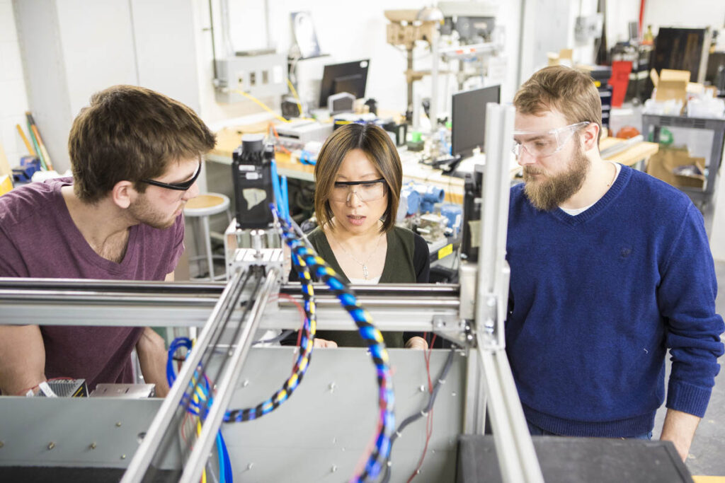 Instructor showing students how to operate device in a lab