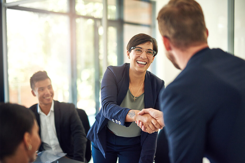 Man and woman shaking hands in a meeting room