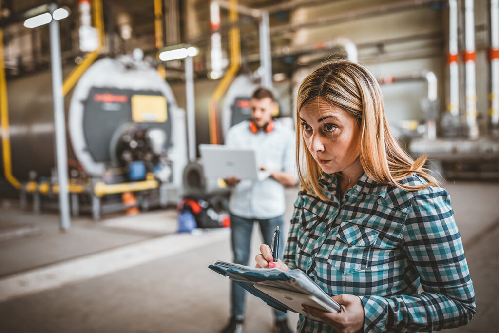 Woman taking notes in an industrial setting