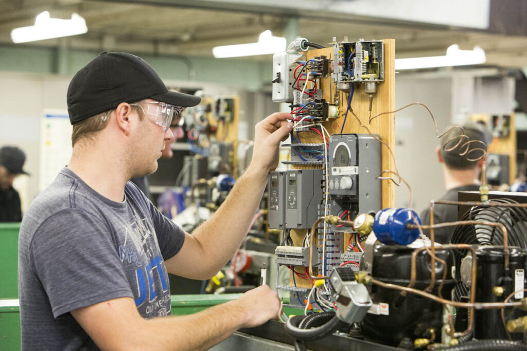 Student wiring some boxes in a lab