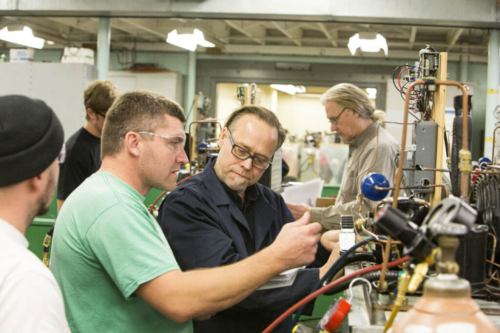 Instructor watching student control gauges in a lab