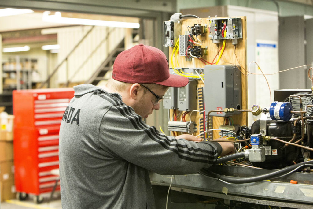 Student wiring some boxes in a lab