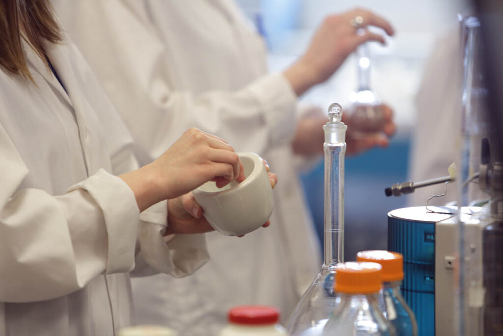 Science students mixing something in a bowl in a lab