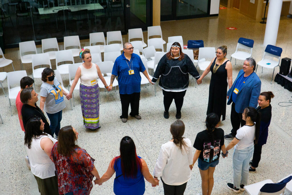 Large group of people standing in a circle and holding hands