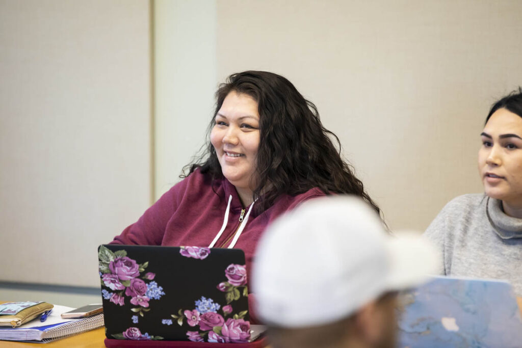 Smiling student sitting at desk in classroom