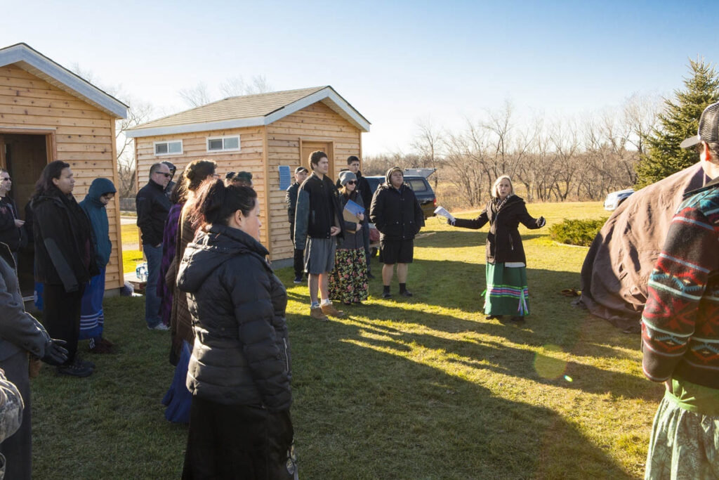 People gathered outside by a sweat lodge for a ceremony