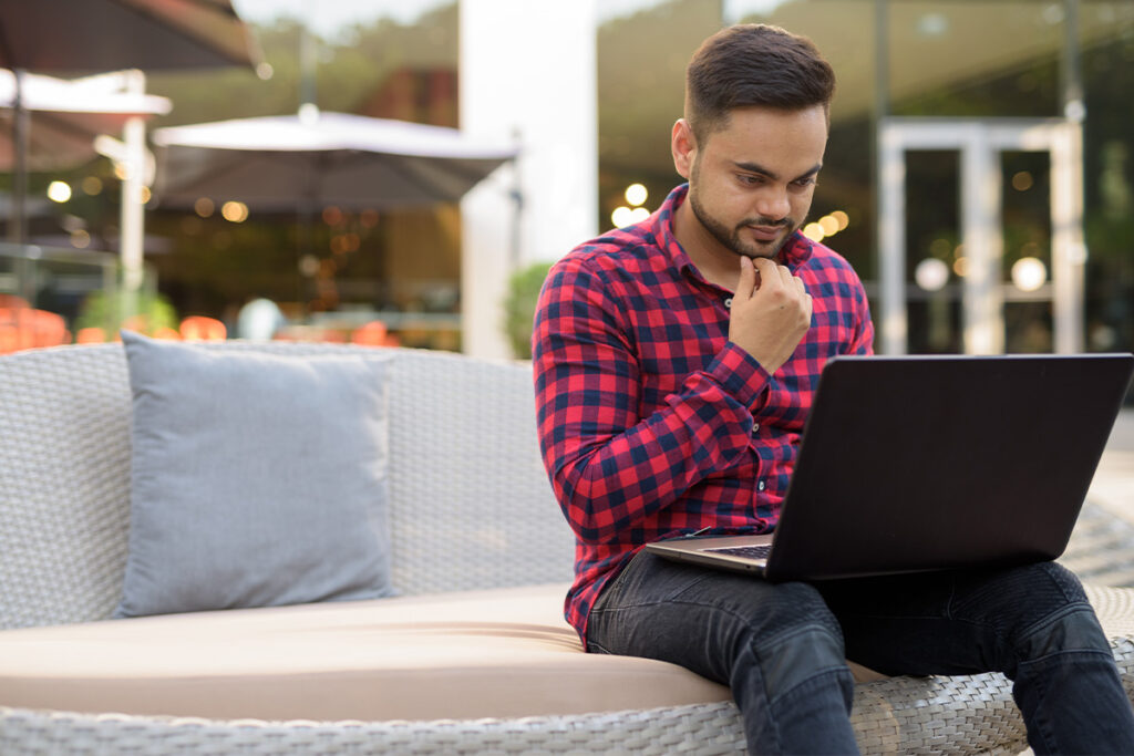 Guy working on a laptop on a patio