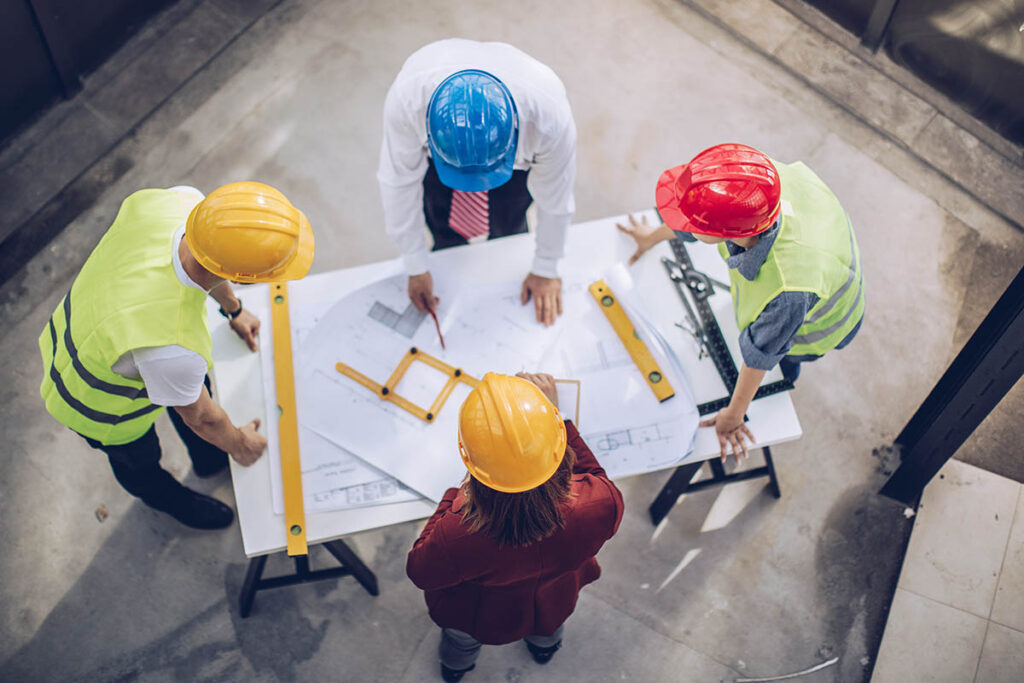 Engineers looking at blueprints at a construction site