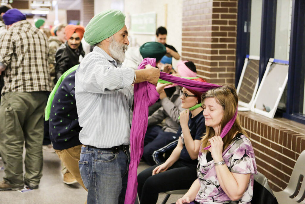 Man tying turban on girl's head
