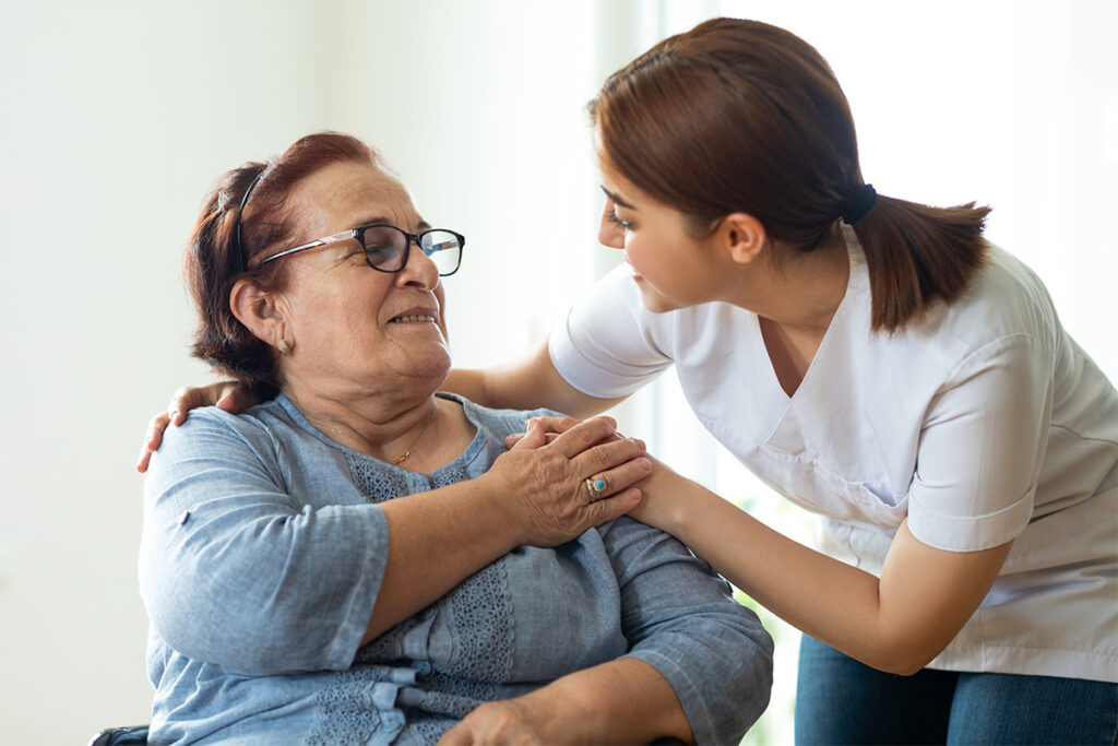 Woman talking to elderly woman in a caring manner