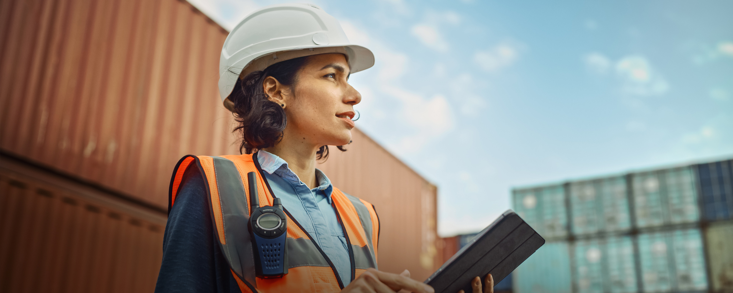 Woman with a hard hat, safety vest and tablet